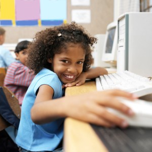 Young Girl at School Holding a Computer Mouse